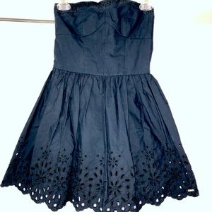 Navy blue strapless dress with eyelet detail.